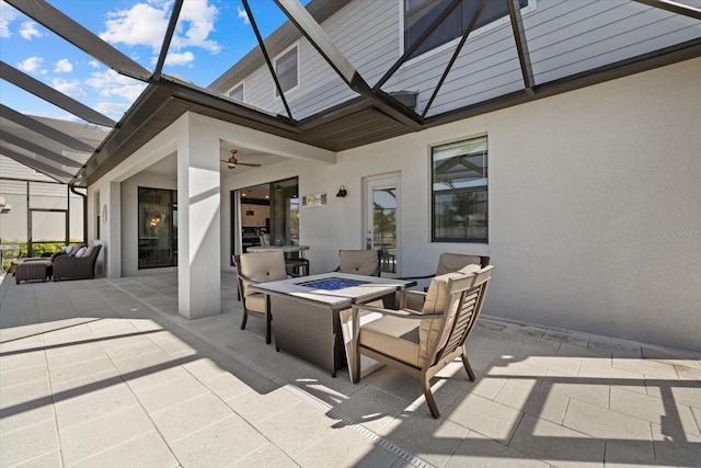 view of patio / terrace featuring an outdoor living space with a fire pit, a lanai, and a ceiling fan