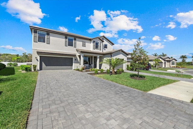 view of front of house featuring a front yard, decorative driveway, and a garage