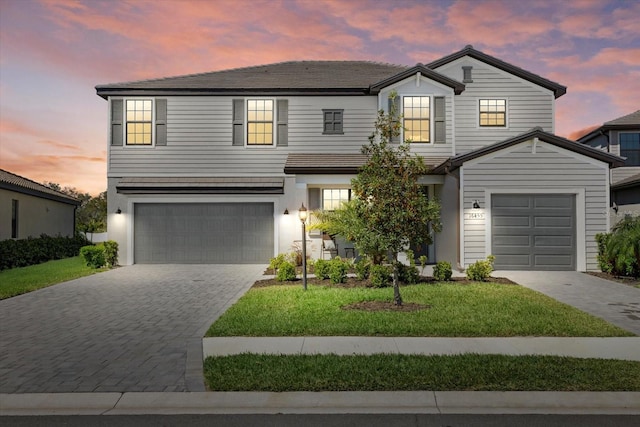 traditional-style home featuring decorative driveway and a garage