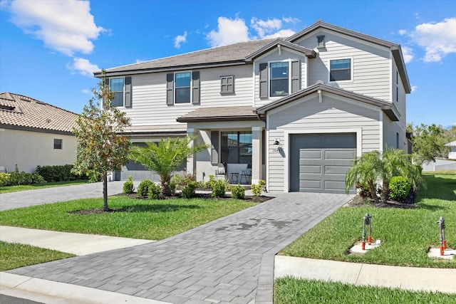 traditional home with a front yard, decorative driveway, and a garage