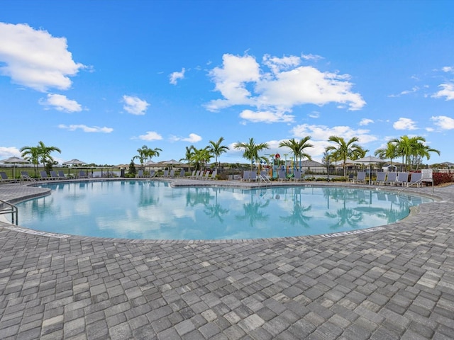 community pool with a patio and fence