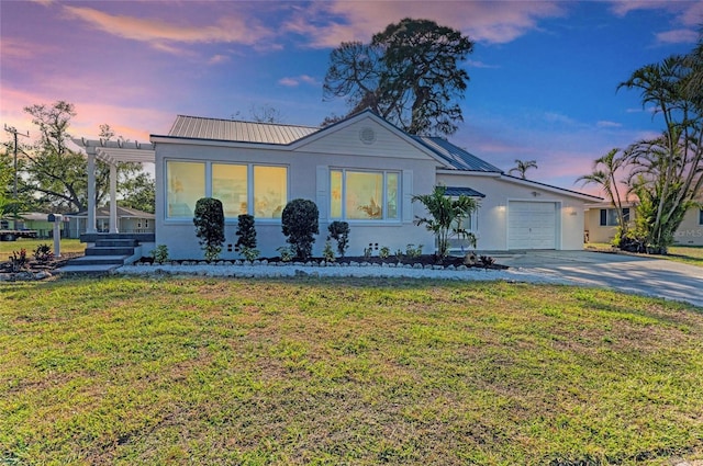 view of front of property with stucco siding, concrete driveway, metal roof, and a garage