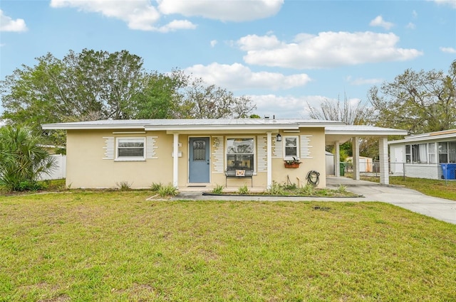 view of front of house featuring stucco siding, an attached carport, driveway, and fence