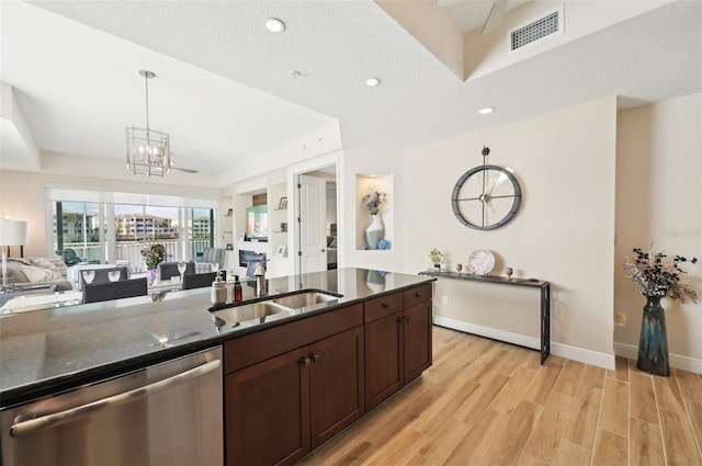 kitchen with visible vents, light wood finished floors, a sink, stainless steel dishwasher, and open floor plan