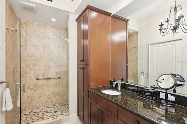 bathroom featuring a chandelier, visible vents, a shower stall, and vanity