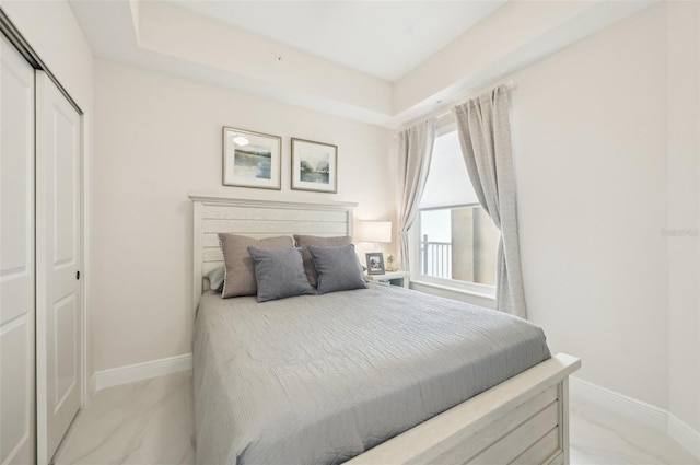 bedroom with a closet, baseboards, and marble finish floor