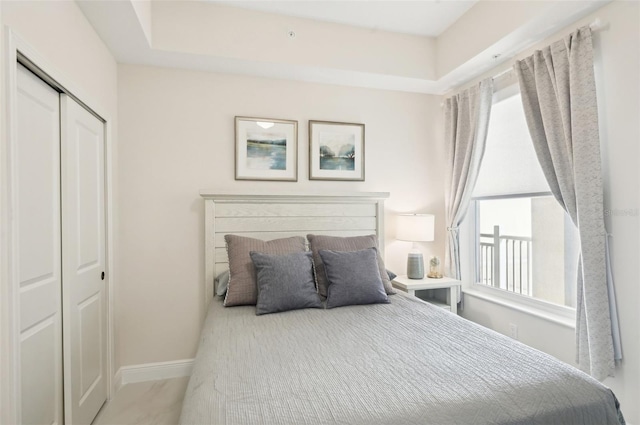 bedroom with baseboards and a closet