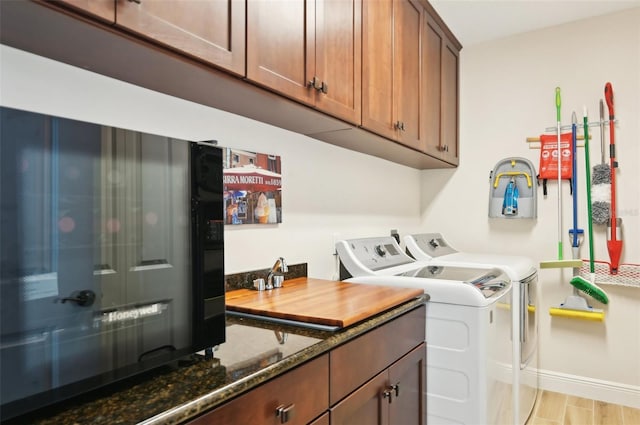 washroom with laundry area, washer and dryer, light wood-style floors, and baseboards