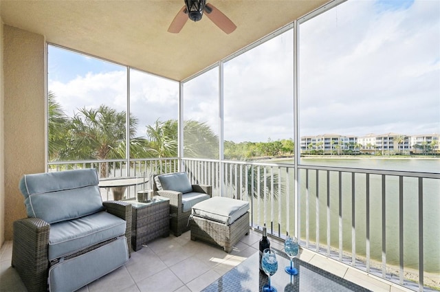 sunroom / solarium featuring a water view and a ceiling fan