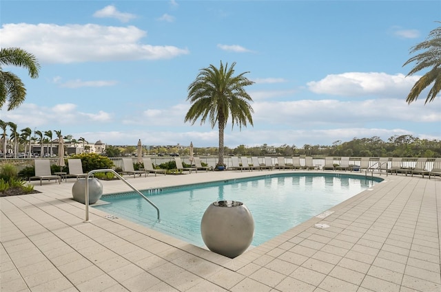 pool with a patio and fence