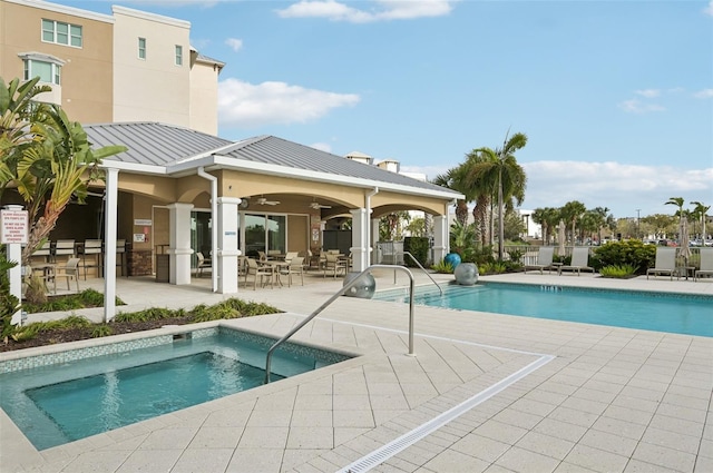 community pool with a community hot tub, fence, ceiling fan, and a patio area