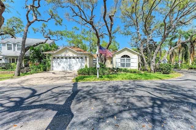 view of front of property with a front yard, a garage, and driveway