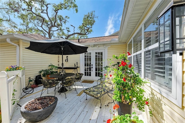 deck with french doors and outdoor dining area