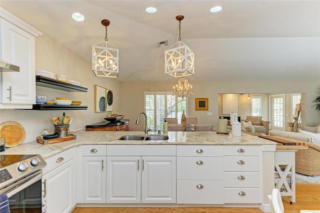 kitchen featuring visible vents, an inviting chandelier, a sink, vaulted ceiling, and open floor plan