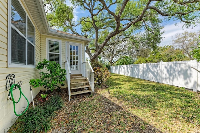 view of yard featuring entry steps and fence