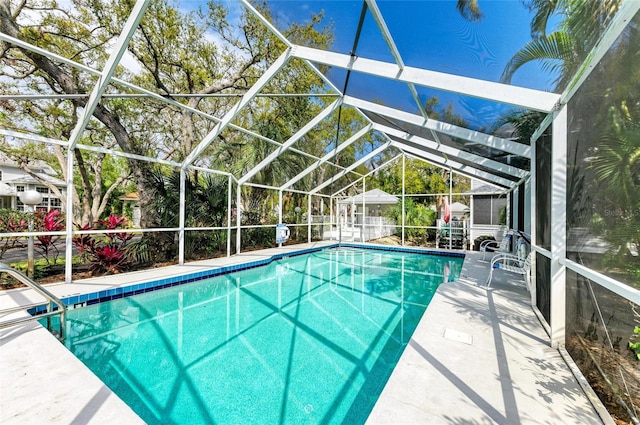 outdoor pool featuring glass enclosure and a patio