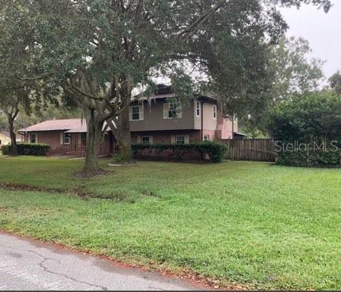 tri-level home featuring a front yard and fence