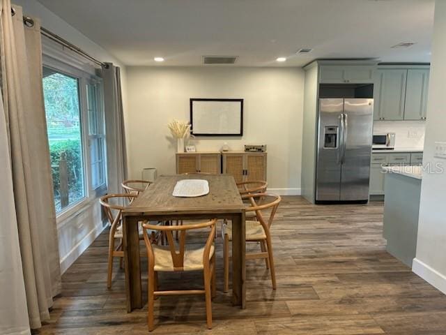 dining room featuring visible vents, baseboards, and wood finished floors