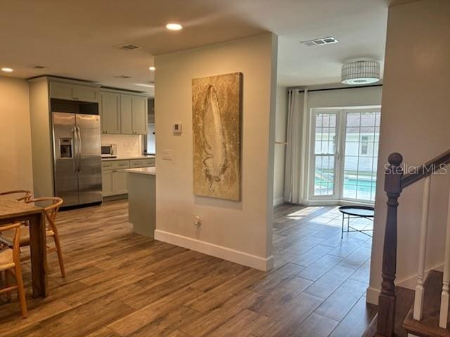 hall featuring visible vents, recessed lighting, baseboards, and wood finished floors