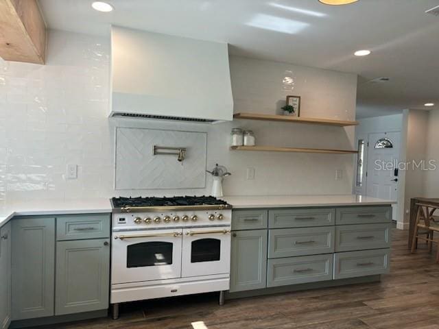 kitchen featuring decorative backsplash, range with two ovens, dark wood-style floors, and gray cabinetry