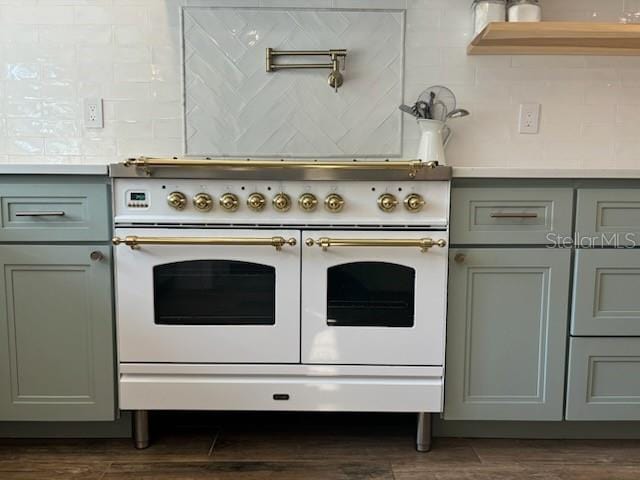 kitchen with tasteful backsplash, dark wood finished floors, double oven range, light countertops, and gray cabinets