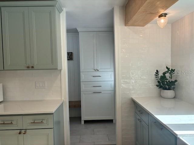 kitchen with light countertops, light tile patterned floors, tile walls, and backsplash