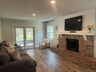 living room with recessed lighting, wood finished floors, and a fireplace