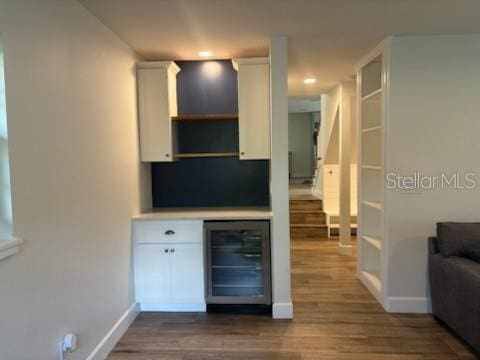 interior space with wine cooler, baseboards, and dark wood-style flooring