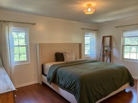 bedroom with baseboards and wood finished floors