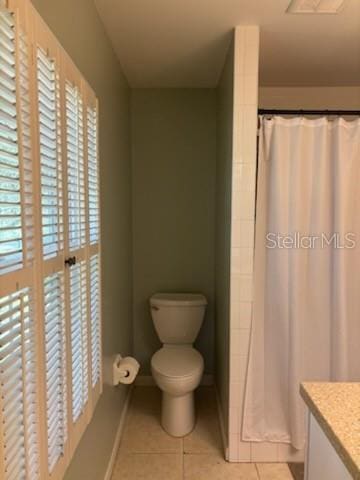 full bathroom featuring tile patterned floors, toilet, a shower with shower curtain, and vanity