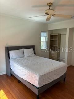 bedroom with baseboards, wood finished floors, and a ceiling fan