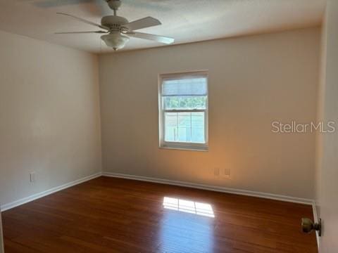 unfurnished room featuring baseboards, wood finished floors, and a ceiling fan