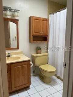 full bath with vanity, curtained shower, toilet, and tile patterned flooring