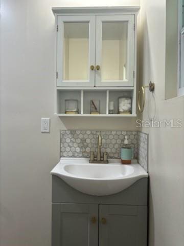 bathroom with tasteful backsplash and vanity