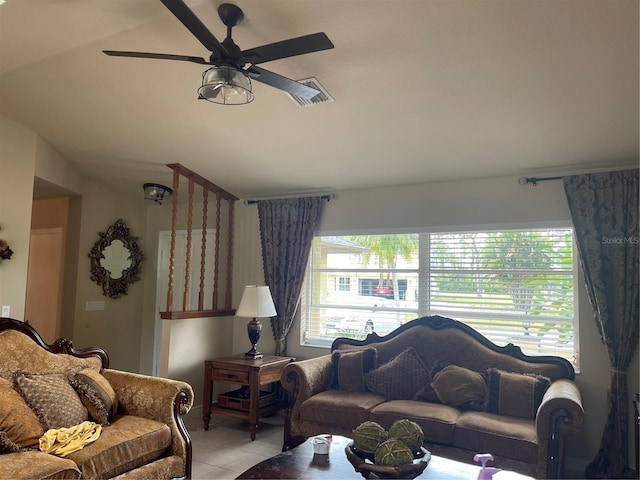 living area with light tile patterned floors, visible vents, a ceiling fan, and vaulted ceiling