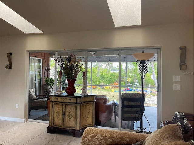 living room with light tile patterned floors, baseboards, and a skylight