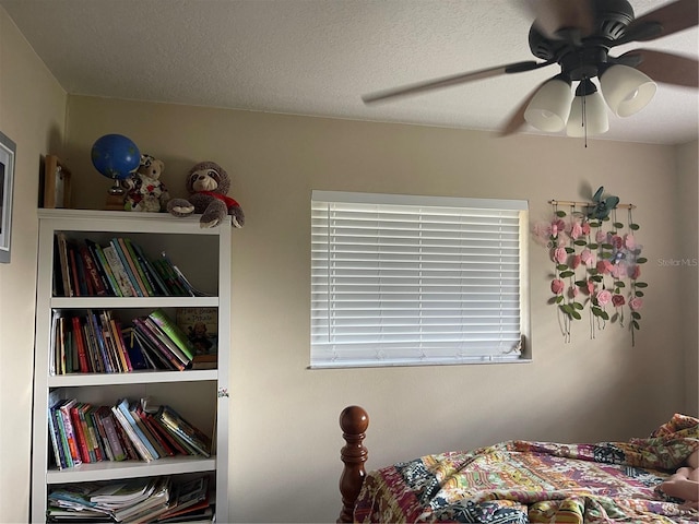 bedroom with a ceiling fan and a textured ceiling