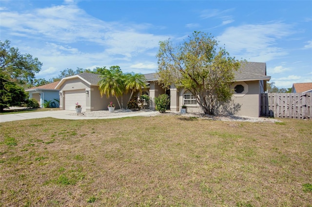 view of front of property featuring fence, driveway, stucco siding, a front lawn, and a garage