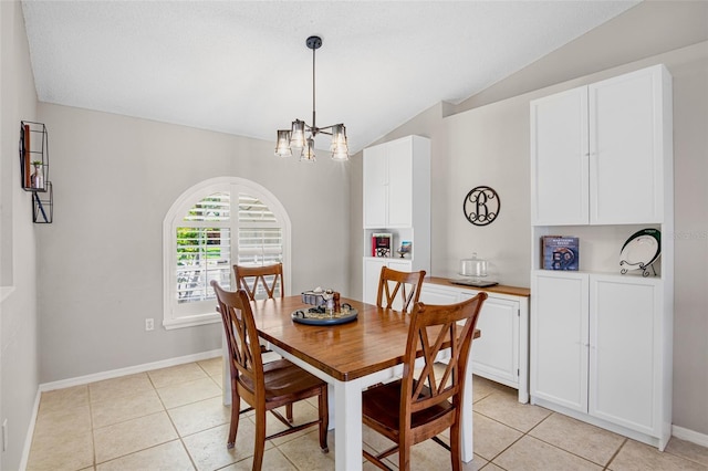 dining room with light tile patterned floors, baseboards, lofted ceiling, and a chandelier