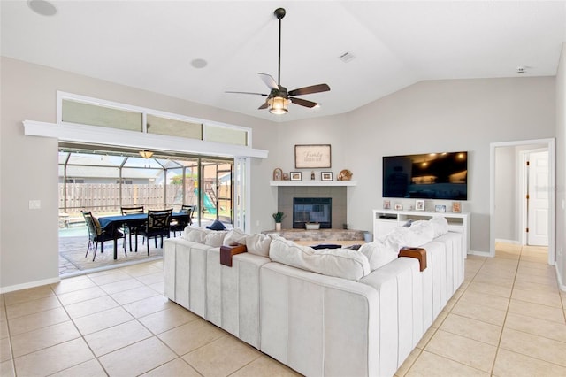 living room featuring visible vents, ceiling fan, vaulted ceiling, a fireplace, and light tile patterned flooring