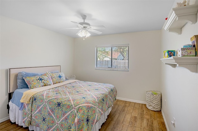 bedroom featuring ceiling fan, baseboards, and wood finished floors