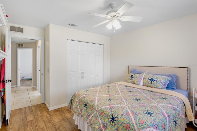 bedroom featuring a closet, visible vents, light wood-style flooring, and a ceiling fan