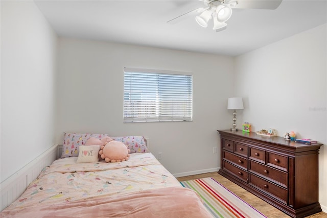 bedroom featuring light wood-type flooring, baseboards, and a ceiling fan