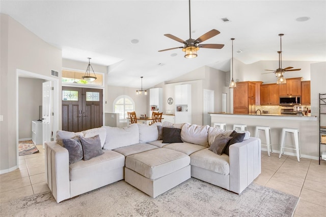 living room with light tile patterned floors, a ceiling fan, visible vents, and baseboards