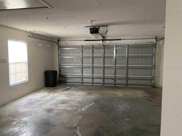 garage with concrete block wall and a garage door opener