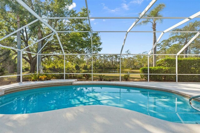 7300 Wax Myrtle Way, Sarasota, FL 34241 - outdoor pool with a patio, glass enclosure, view of scattered trees, and a water view