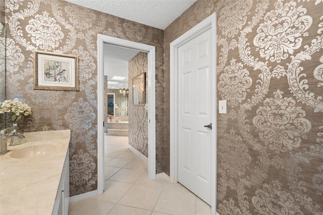 7300 Wax Myrtle Way, Sarasota, FL 34241 - bathroom with wallpapered walls, tile patterned flooring, vanity, and a textured ceiling