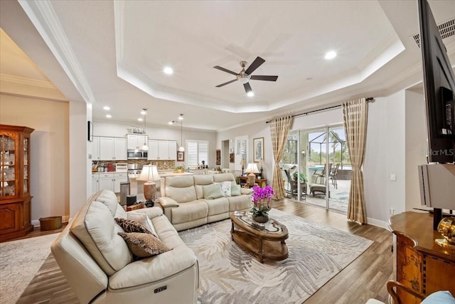 4691 Claremont Park Dr, Bradenton, FL 34211 - living area with a tray ceiling, ornamental molding, ceiling fan, light wood-style floors, and recessed lighting