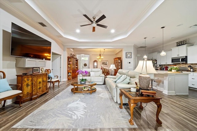 4691 Claremont Park Dr, Bradenton, FL 34211 - living room featuring ceiling fan, a raised ceiling, ornamental molding, wood finished floors, and a chandelier