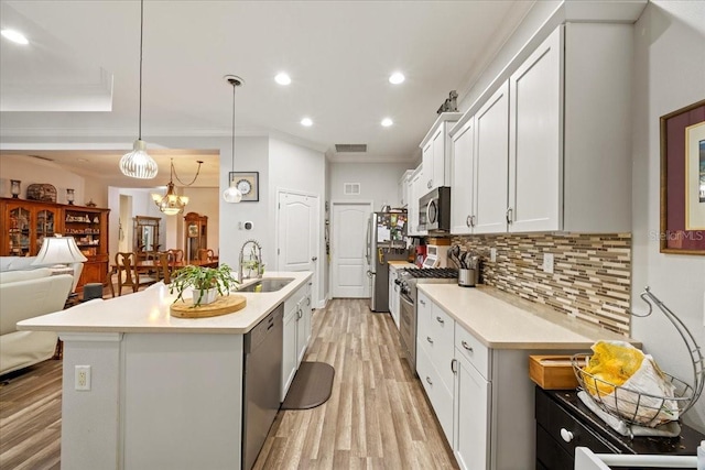 4691 Claremont Park Dr, Bradenton, FL 34211 - kitchen featuring stainless steel appliances, tasteful backsplash, crown molding, open floor plan, and light wood-style floors